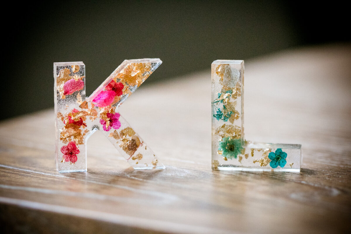 Buchstaben aus transparentem Kunststoff, kreativ mit Blüten verziert